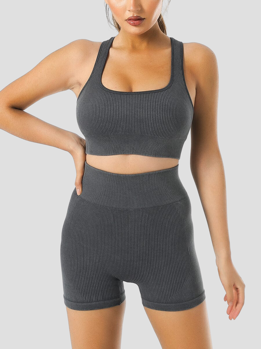 Woman wearing ribbed high-waisted purple activewear shorts and a matching sports bra designed by BodyFlexx.