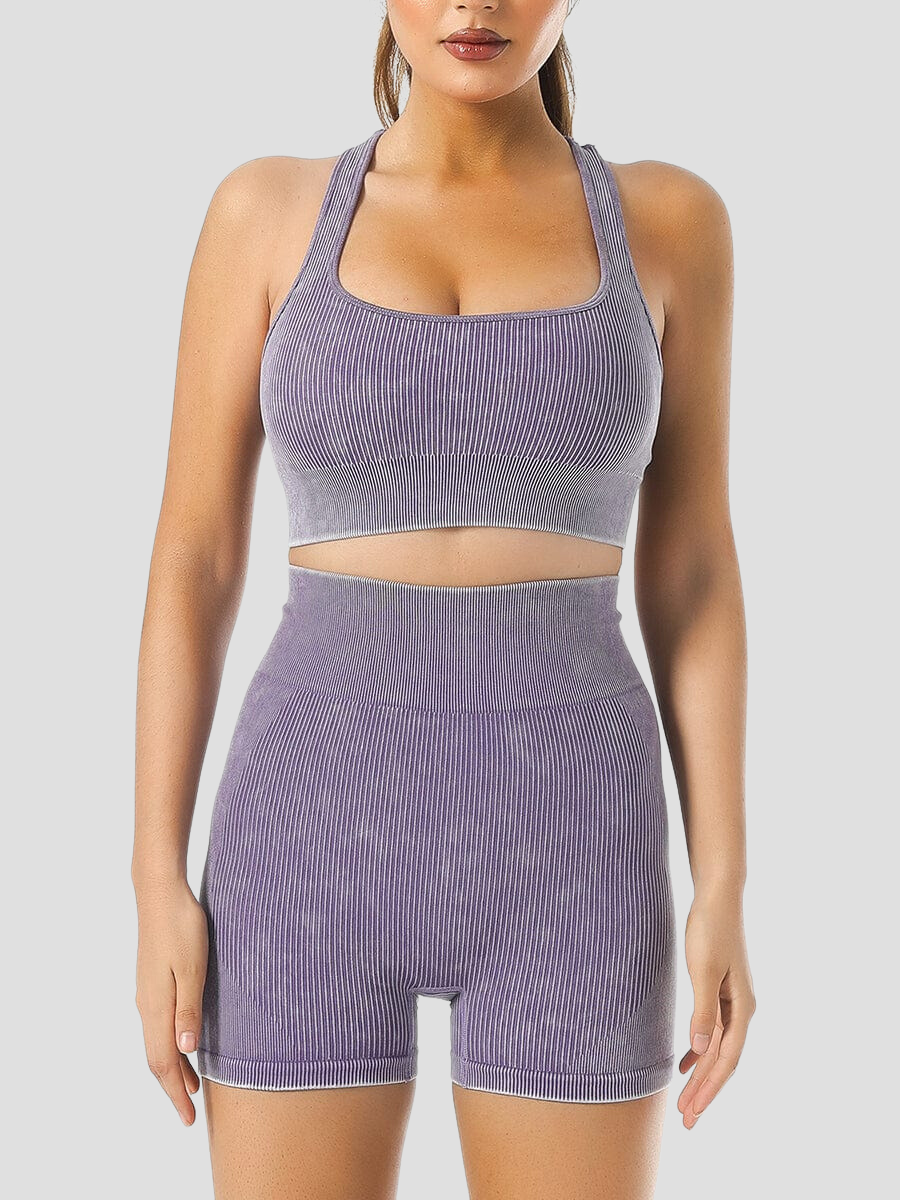 Woman wearing ribbed high-waisted pink activewear shorts and a matching sports bra designed by BodyFlexx.