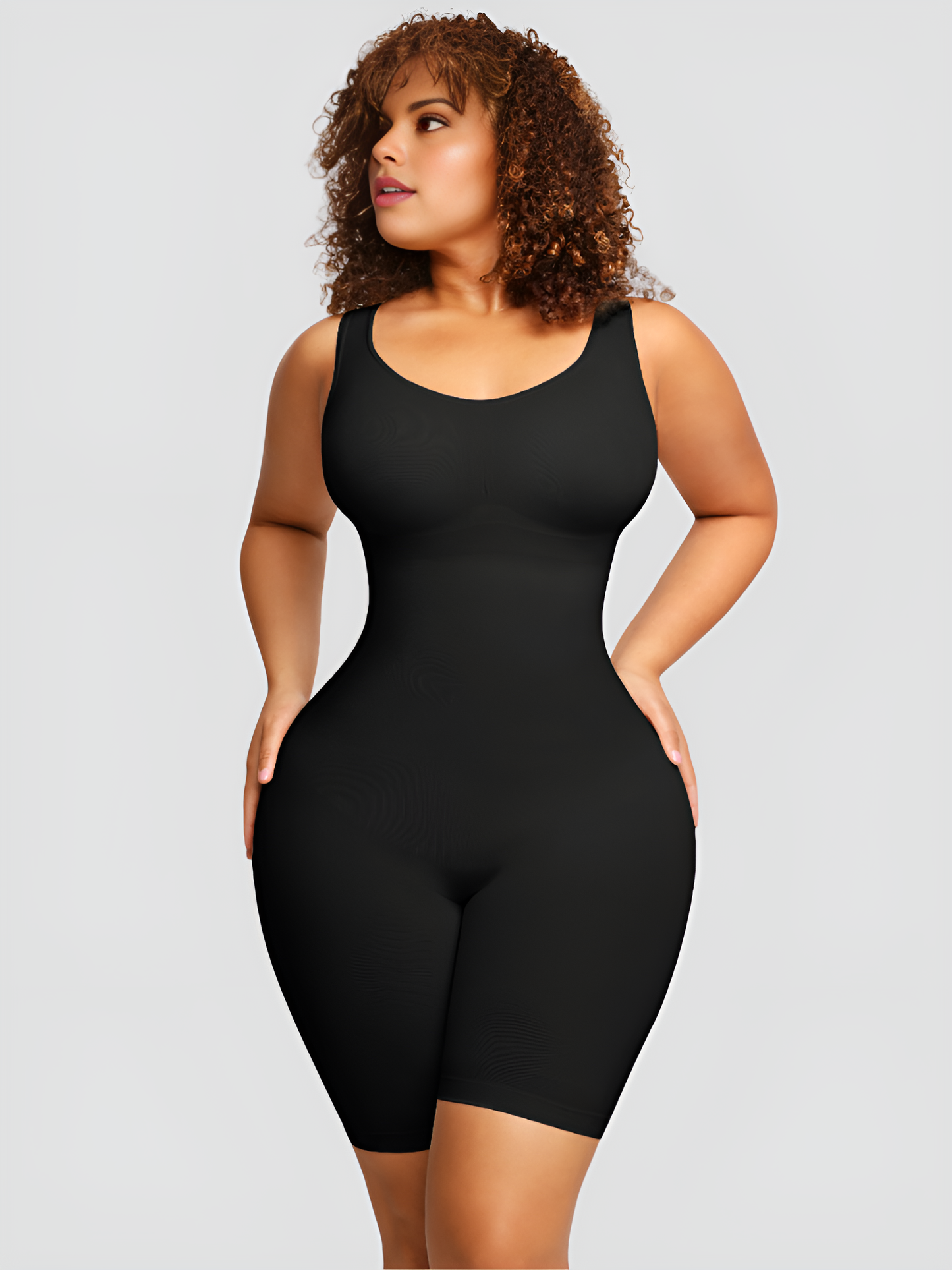 Woman wearing a seamless black mid-thigh shapewear bodysuit designed by BodyFlexx.