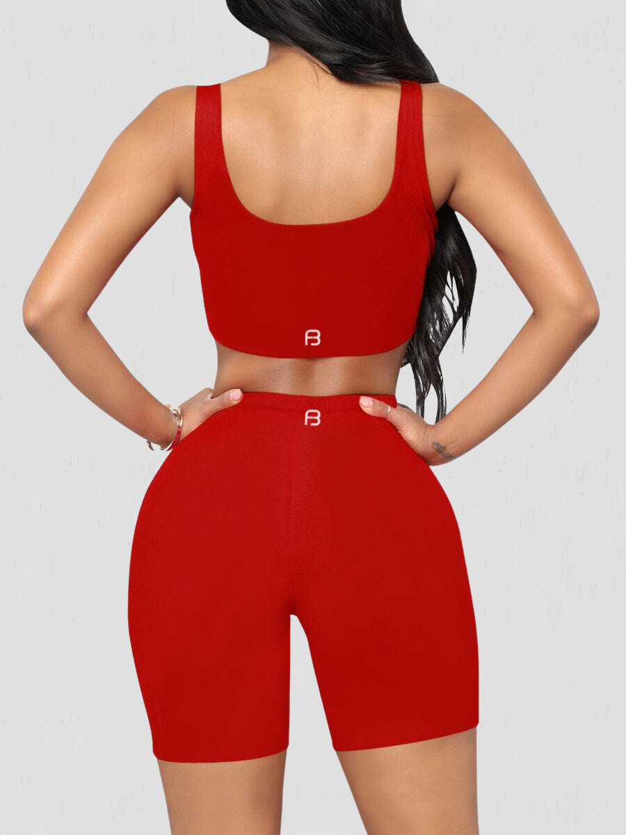 Woman wearing a red matching shorts and sports bra activewear set showing the BodyFlexx logo on the back.
