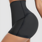 Woman posing wearing black Waist-Training Sauna Shorts with a corset closure by BodyFlexx.
