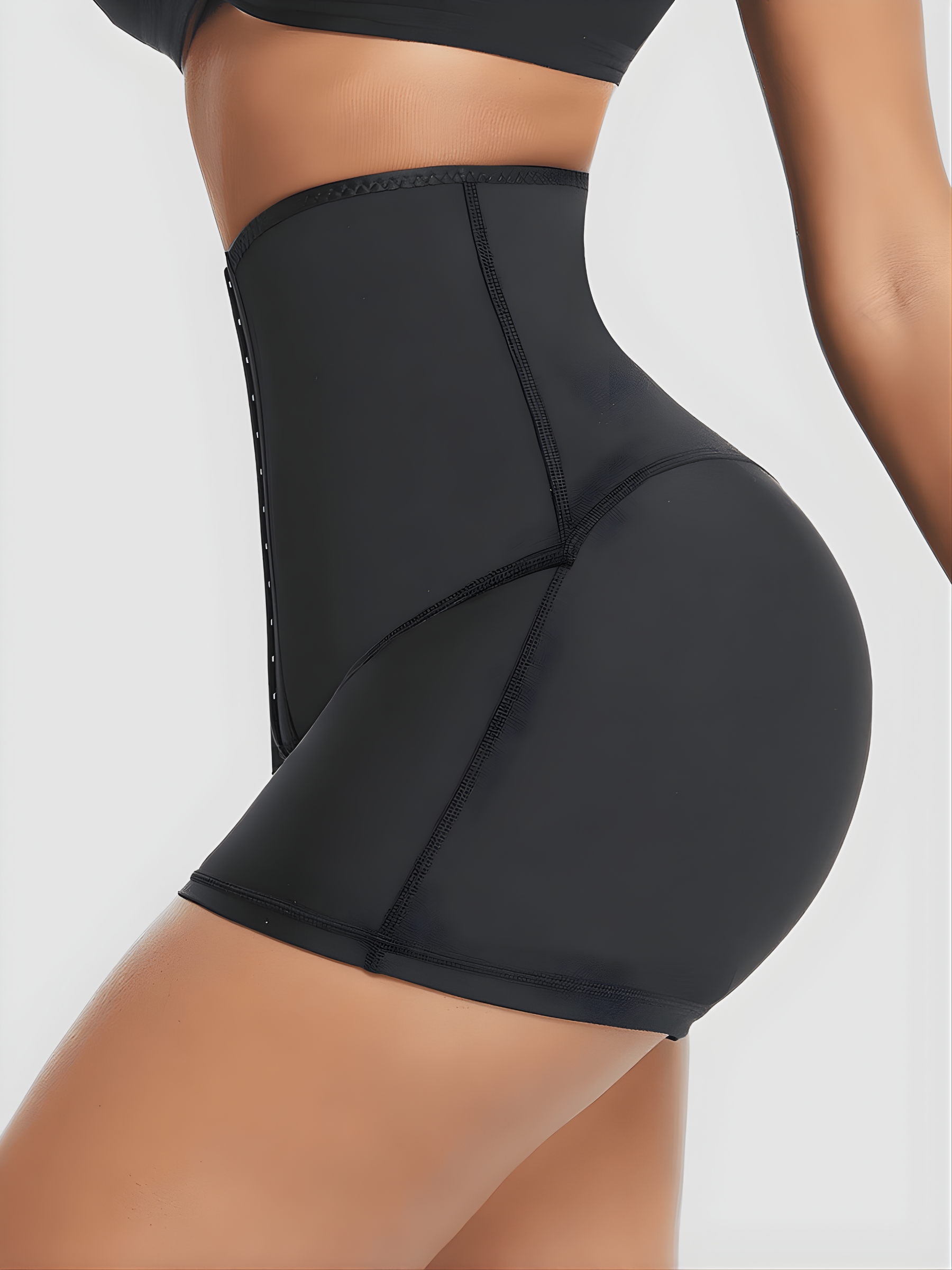 Woman posing wearing black Waist-Training Sauna Shorts with a corset closure by BodyFlexx.
