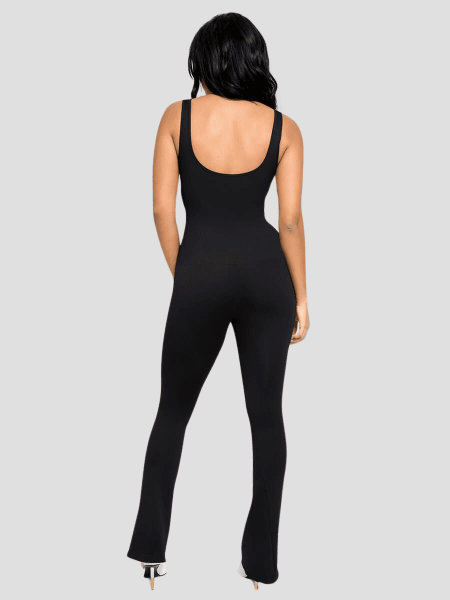 Woman standing backwards wearing a black sleeveless flared jumpsuit with built-in shapewear by BodyFlexx.