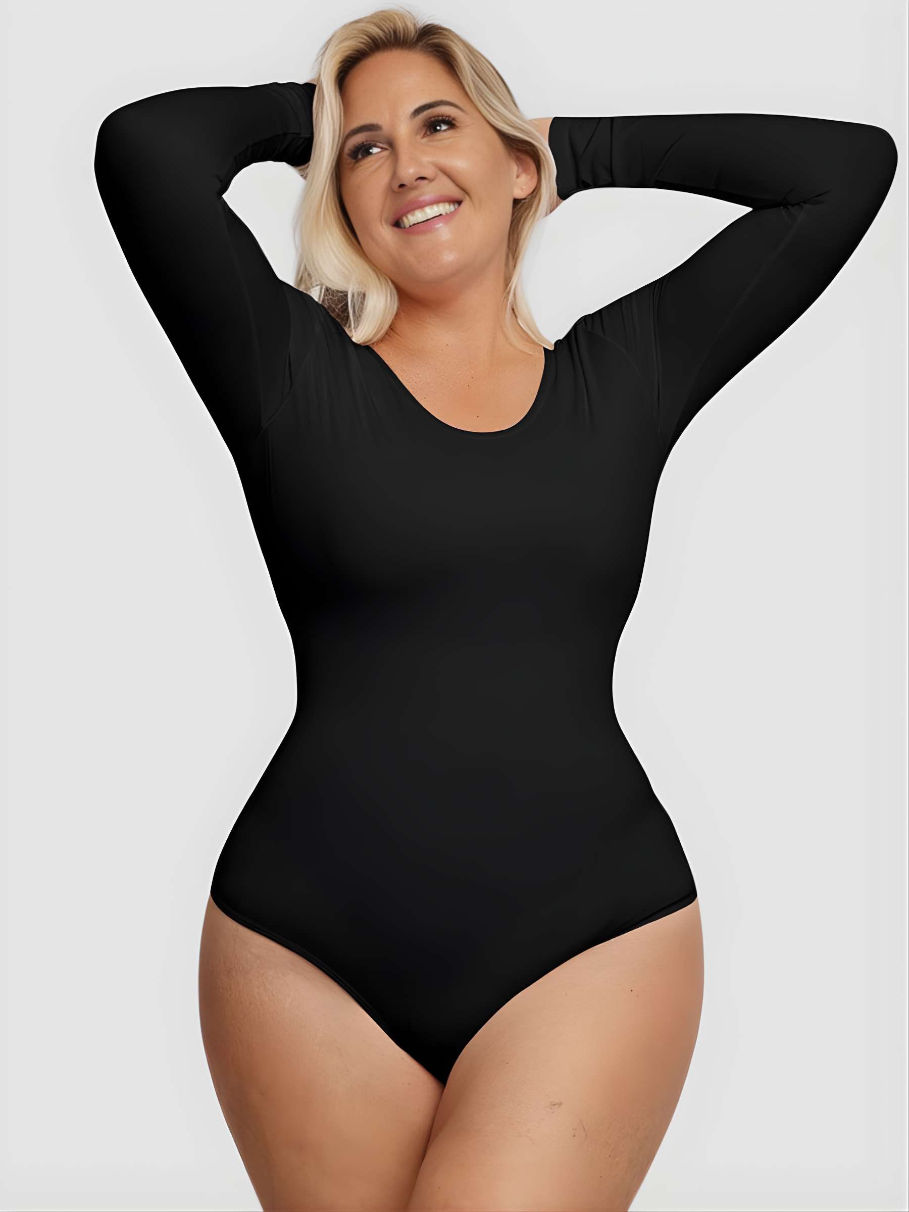 Laughing woman wearing a black long-sleeve bodysuit with built-in shapewear by BodyFlexx.
