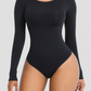Woman posing wearing a black long-sleeve sculpting bodysuit by BodyFlexx Shapewear.