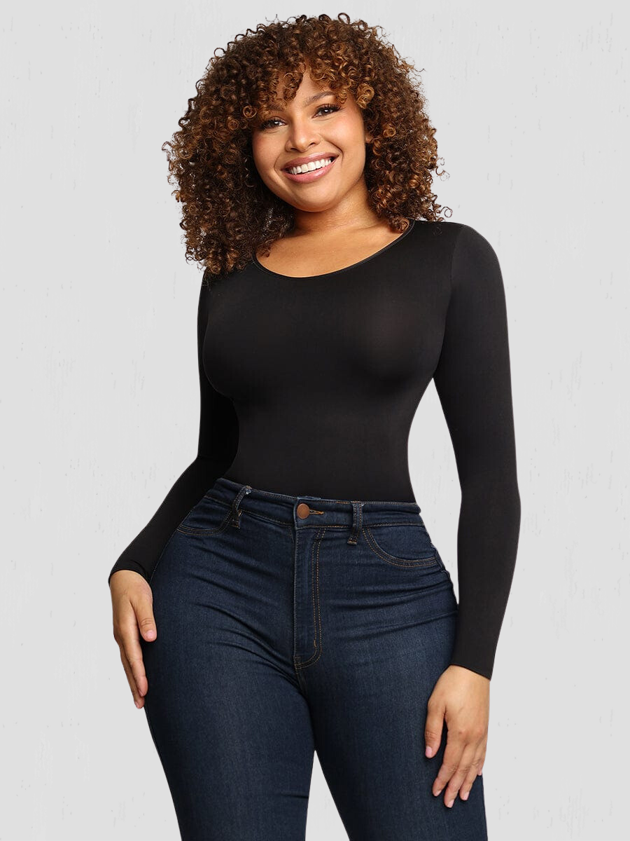 Woman posing wearing a black long-sleeve sculpting bodysuit by BodyFlexx Shapewear with blue jeans.