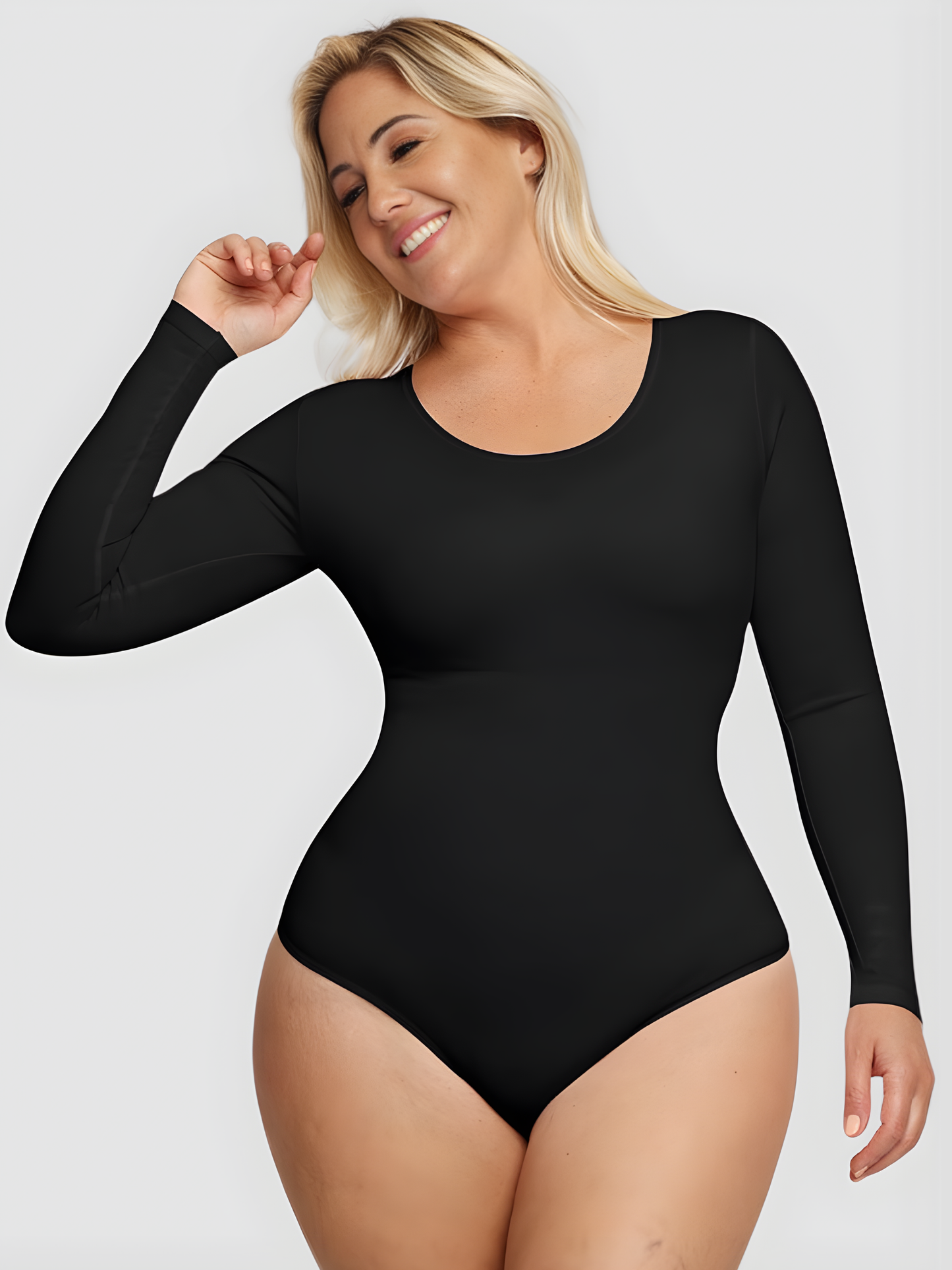 Smiling woman wearing a black long-sleeve bodysuit with built-in shapewear by BodyFlexx.