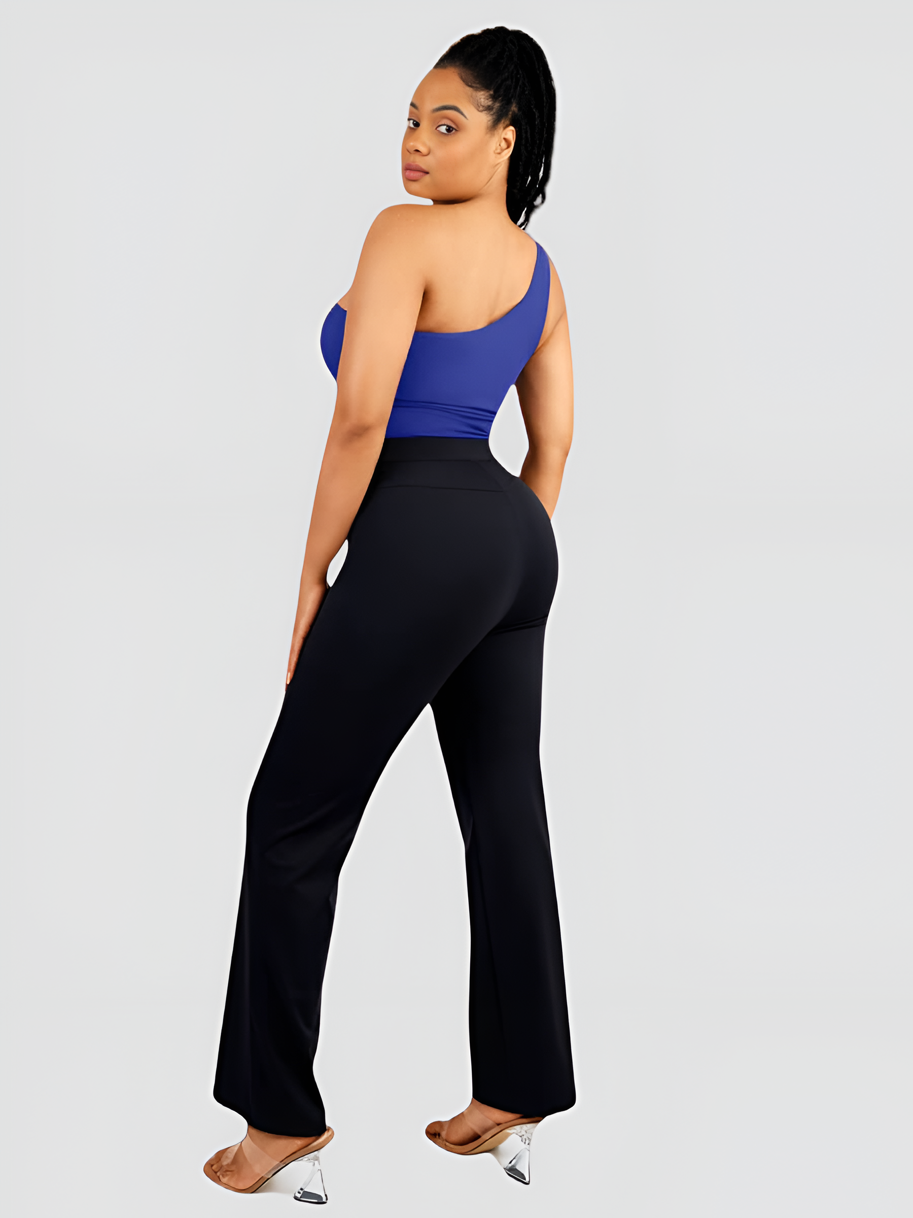A woman posing wearing a blue off-the-shoulder shaping bodysuit with built-in tummy-control shapewear paired with black pants. She is looking back over her shoulder showing off her curves.