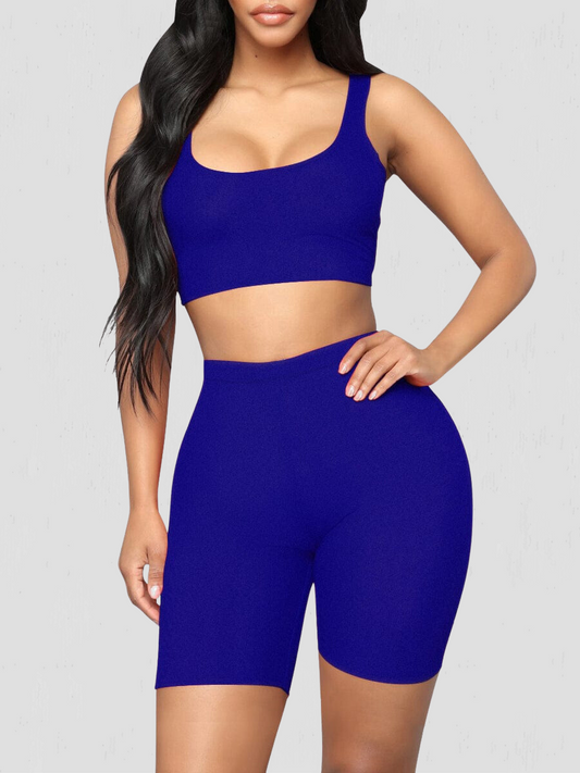 Woman wearing a matching blue shorts and sports bra activewear set by BodyFlexx.