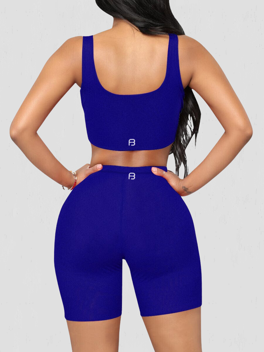 Woman wearing a matching blue shorts and sports bra activewear set showing the BodyFlexx Shapewear logo on the back.