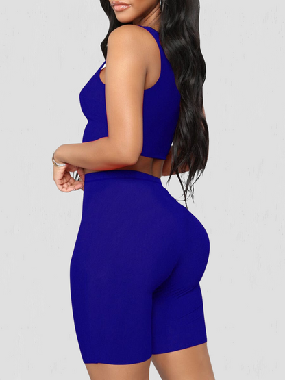 Woman wearing a matching blue shorts and sports bra activewear set by BodyFlexx.