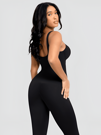 Woman looking over her shoulder wearing a black sleeveless jumpsuit with built-in shapewear by BodyFlexx.