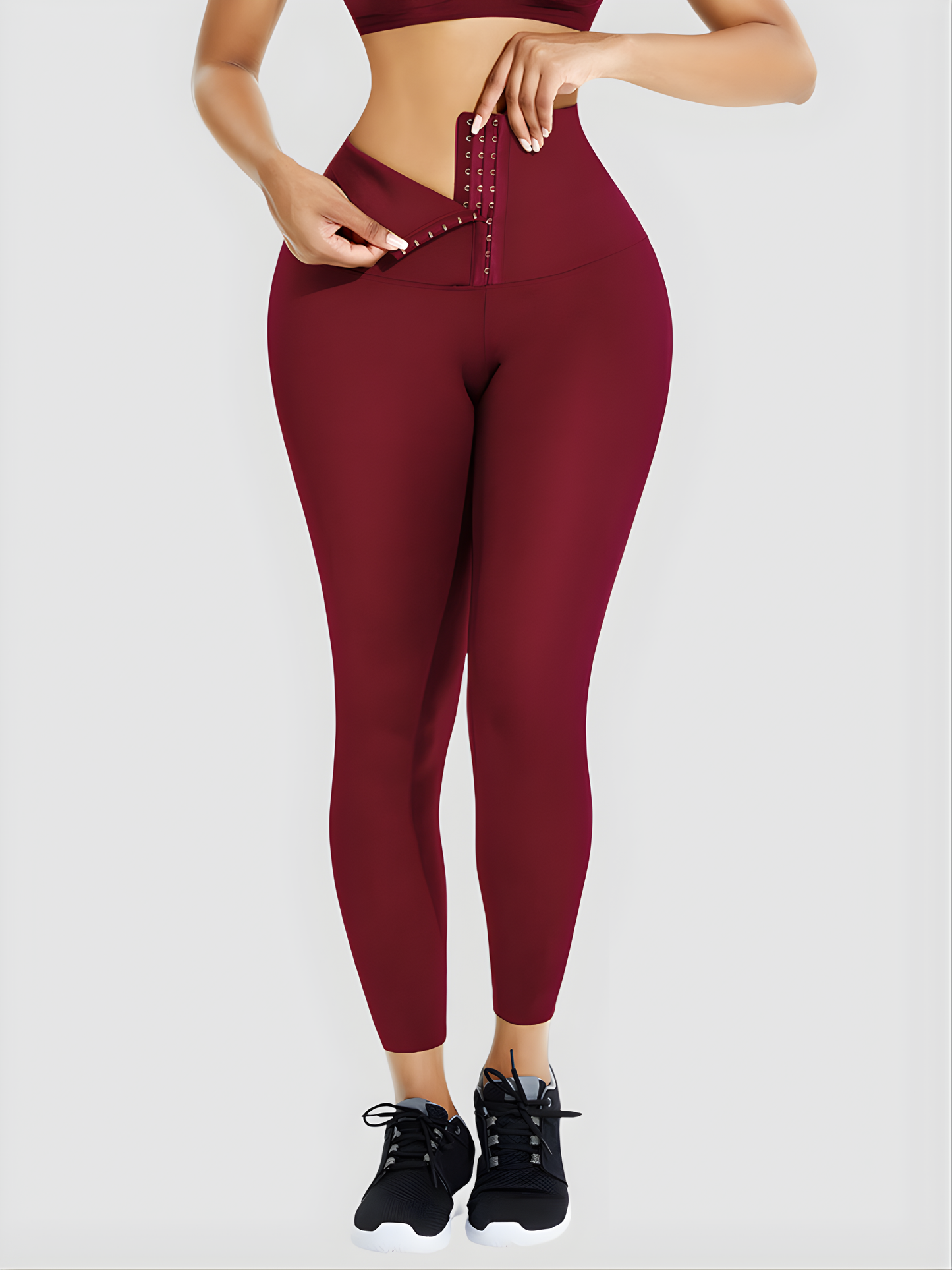 Woman wearing red waist training  leggings with a corset closure designed for tummy-control and cellulite-smoothing by BodyFlexx Shapewear.