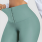 Woman wearing high waisted teal blue green waist training leggings with a 3 row hook-and-eye corset closure by BodyFlexx Shapewear.