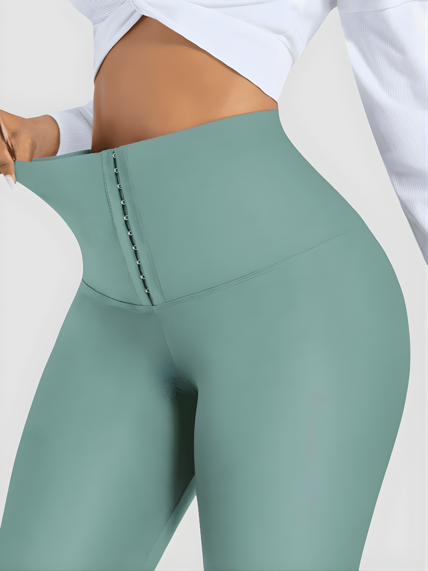Woman wearing high waisted teal blue green waist training leggings with a 3 row hook-and-eye corset closure by BodyFlexx Shapewear.