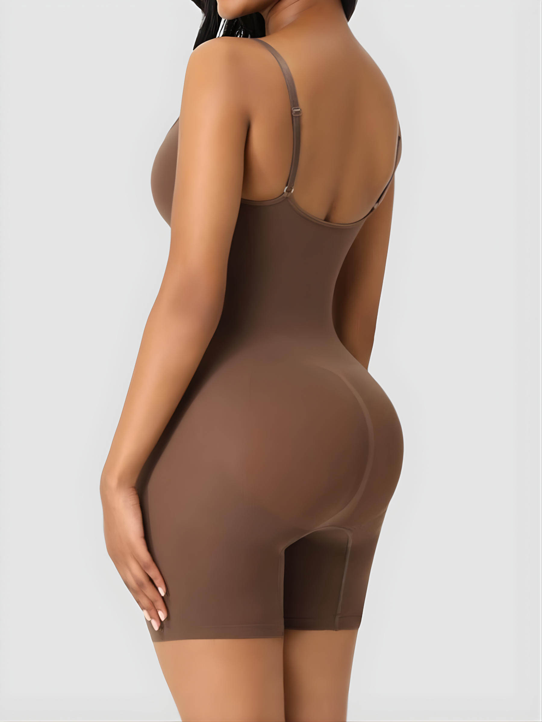 Woman wearing a brown mid-thigh bodysuit shaper by showing off her curves.