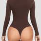 Woman wearing a brown long-sleeve shaping bodysuit showing the thong design.