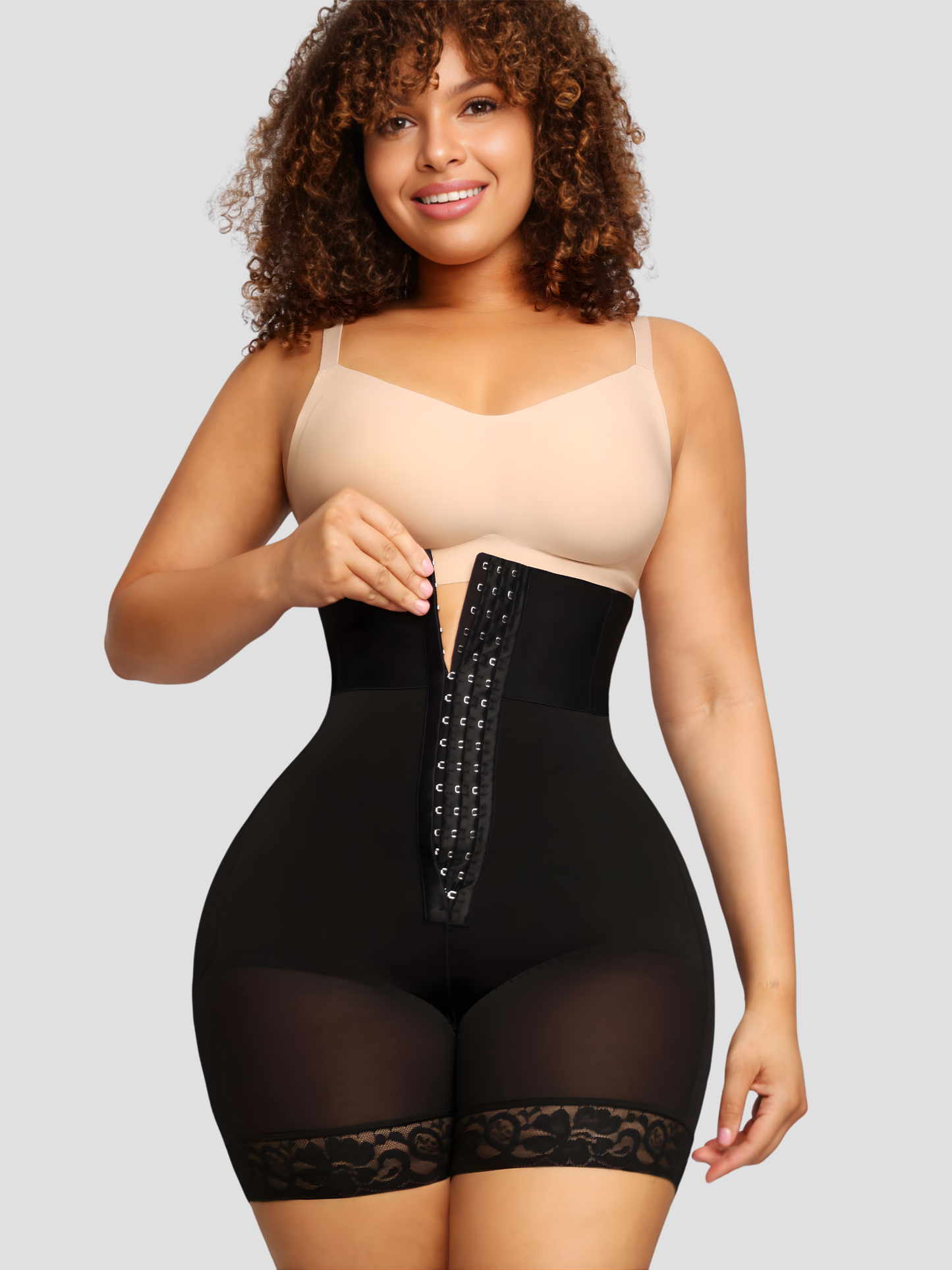 Woman smiling wearing a black Columbian faja corset shapewear garment with lace details.