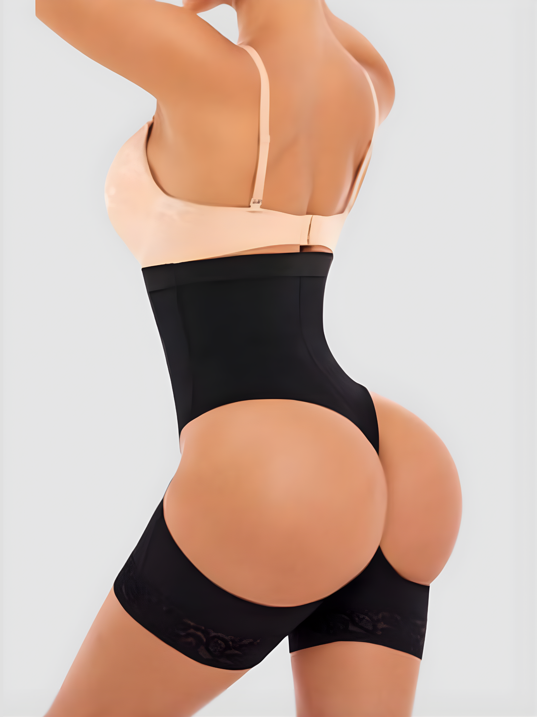 Woman in a black high-waisted Columbian faja shapewear garment with an open hip and bum.