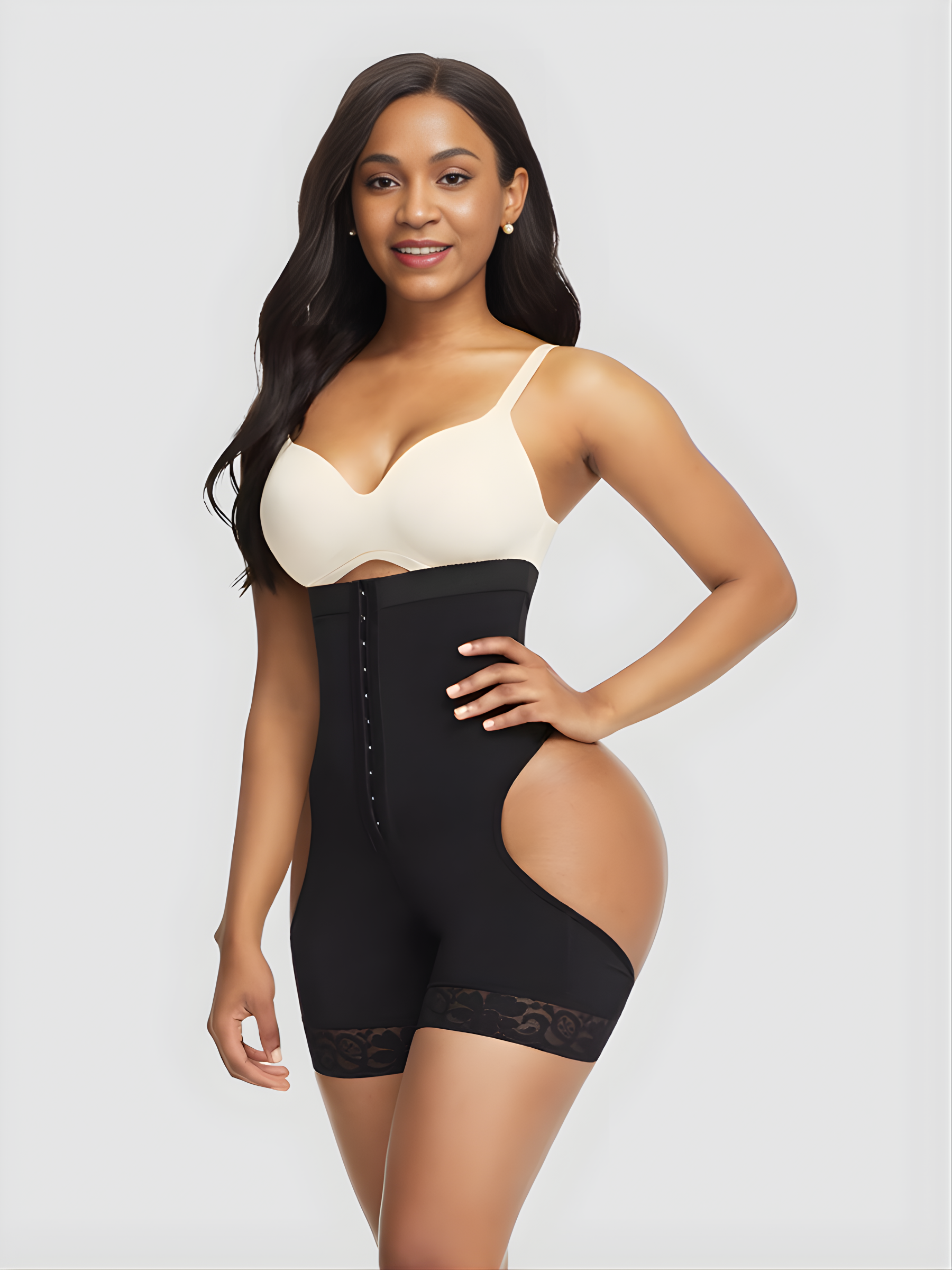 Model wearing a black mid-thigh faja corset shapewear garment with an open hip and bum.