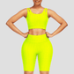 A woman wearing a yellow high-waisted activewear shorts and a matching sports bra with a textured honeycomb pattern.
