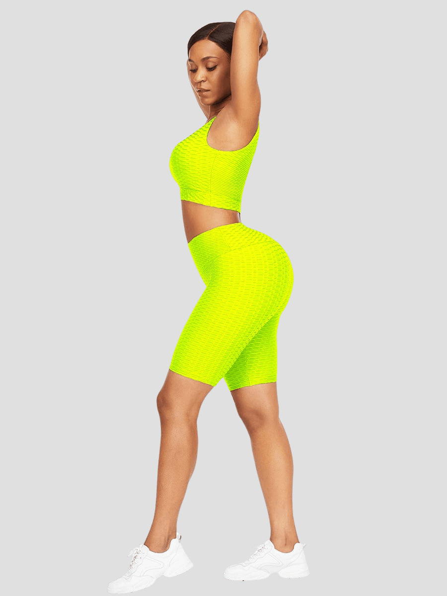 Woman wearing a bright neon yellow tummy-control shorts and sports bra activewear set with a honeycomb pattern and a scrunch bum back seam.