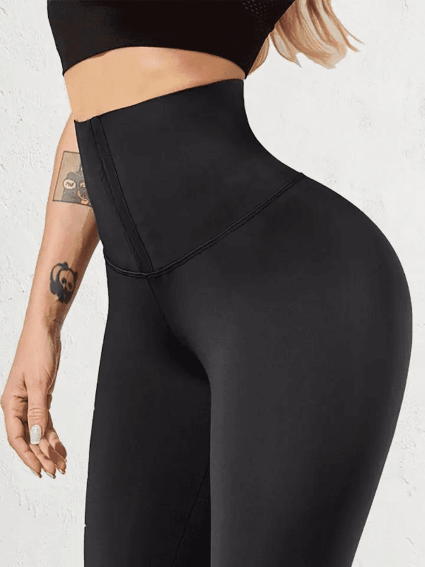 Woman wearing black high waisted corset leggings showing off her backside curves.