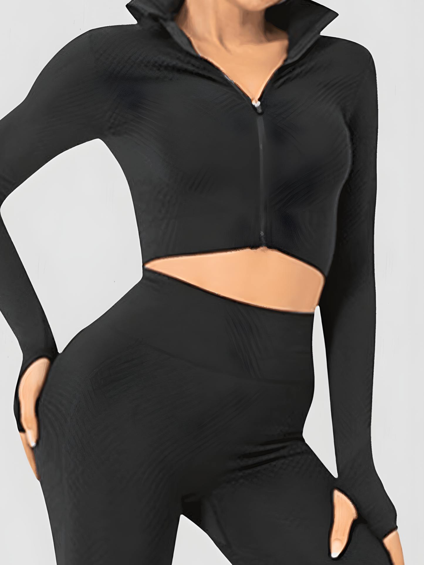 Fitness model posing in a black zippered cropped activewear BBL jacket with matching leggings.