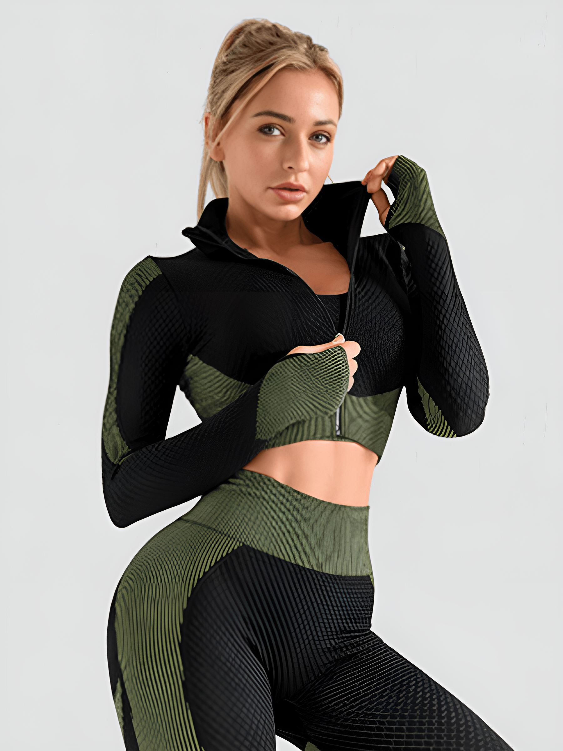 Woman wearing a green and black zippered cropped activewear BBL jacket with matching leggings.