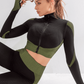 Fitness model posing in a green and black zippered cropped activewear BBL jacket with matching leggings.