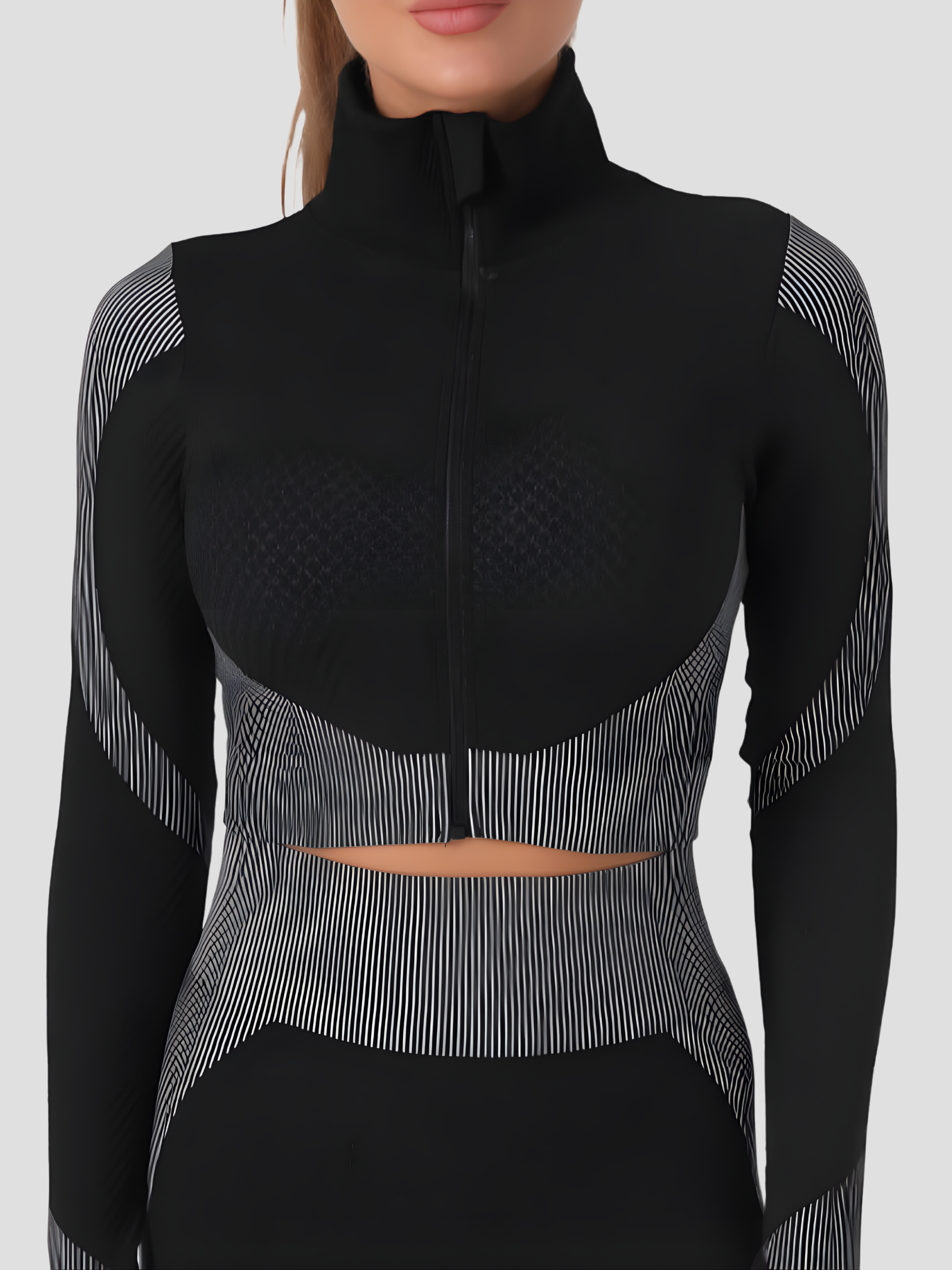 Woman wearing a black and gray cropped activewear BBL jacket with matching leggings.