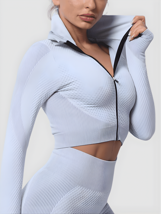 Woman wearing a silver gray zippered cropped activewear BBL jacket by BodyFlexx.