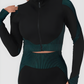 Woman wearing a teal and black zippered cropped activewear BBL jacket with matching leggings.