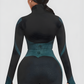 Woman wearing a teal and black zippered cropped activewear BBL jacket with matching leggings.by BodyFlexx