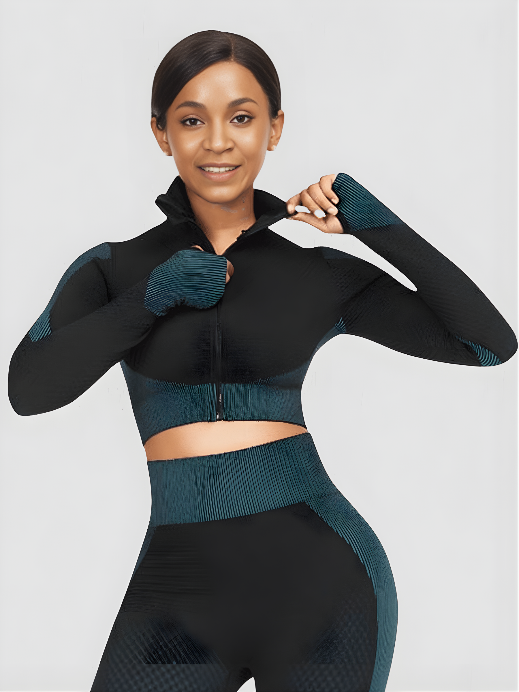 Woman wearing a teal and black zippered cropped activewear BBL jacket with matching leggings.
