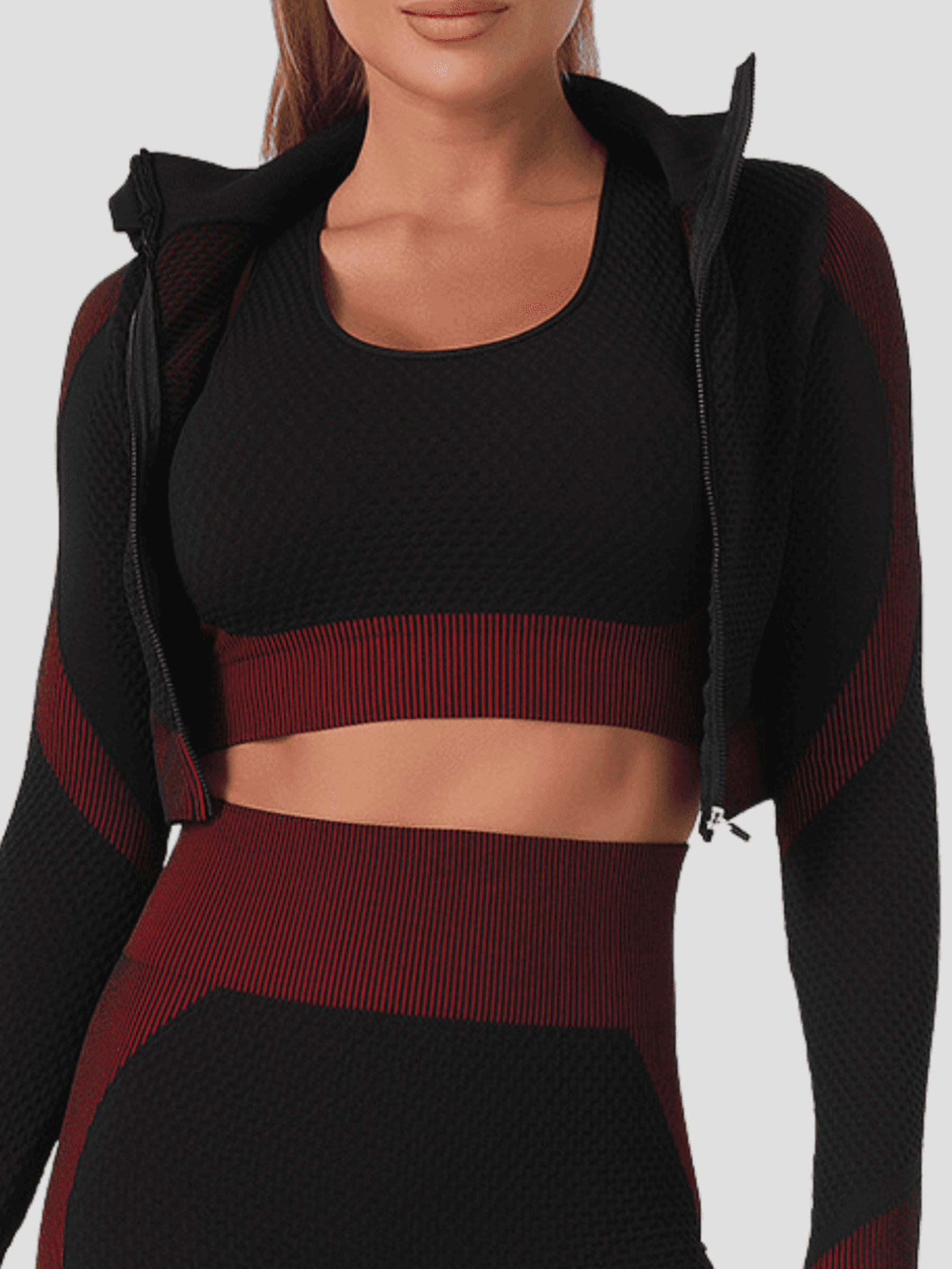 Woman wearing a fuchsia and black zippered cropped activewear BBL jacket with a matching sports bra.