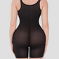 Woman wearing a black sheer open chest bodysuit shapewear standing backwards to show the back view and how it's lifting and shaping her bum.