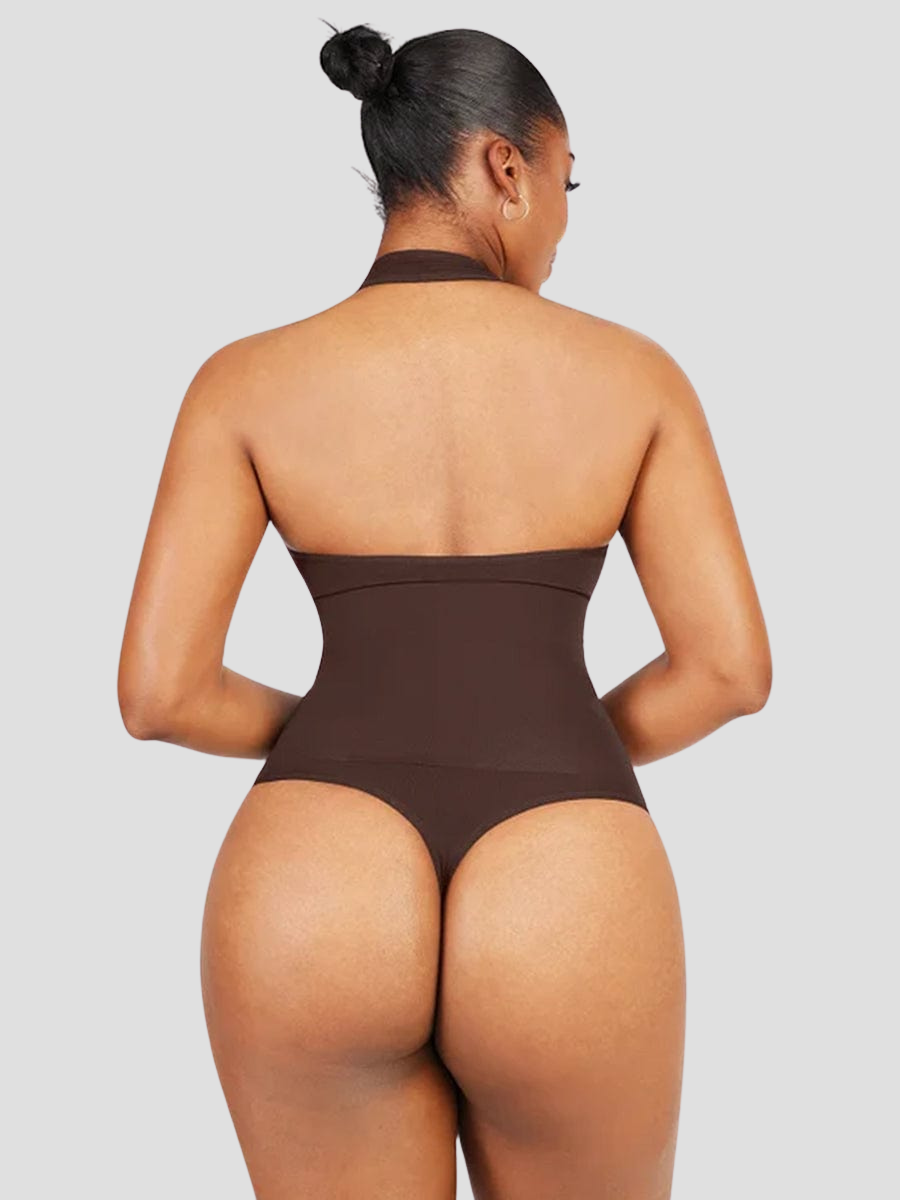 Woman wearing a black halter-style shapewear bodysuit with built-in removable bra padding and a seamless thong design.