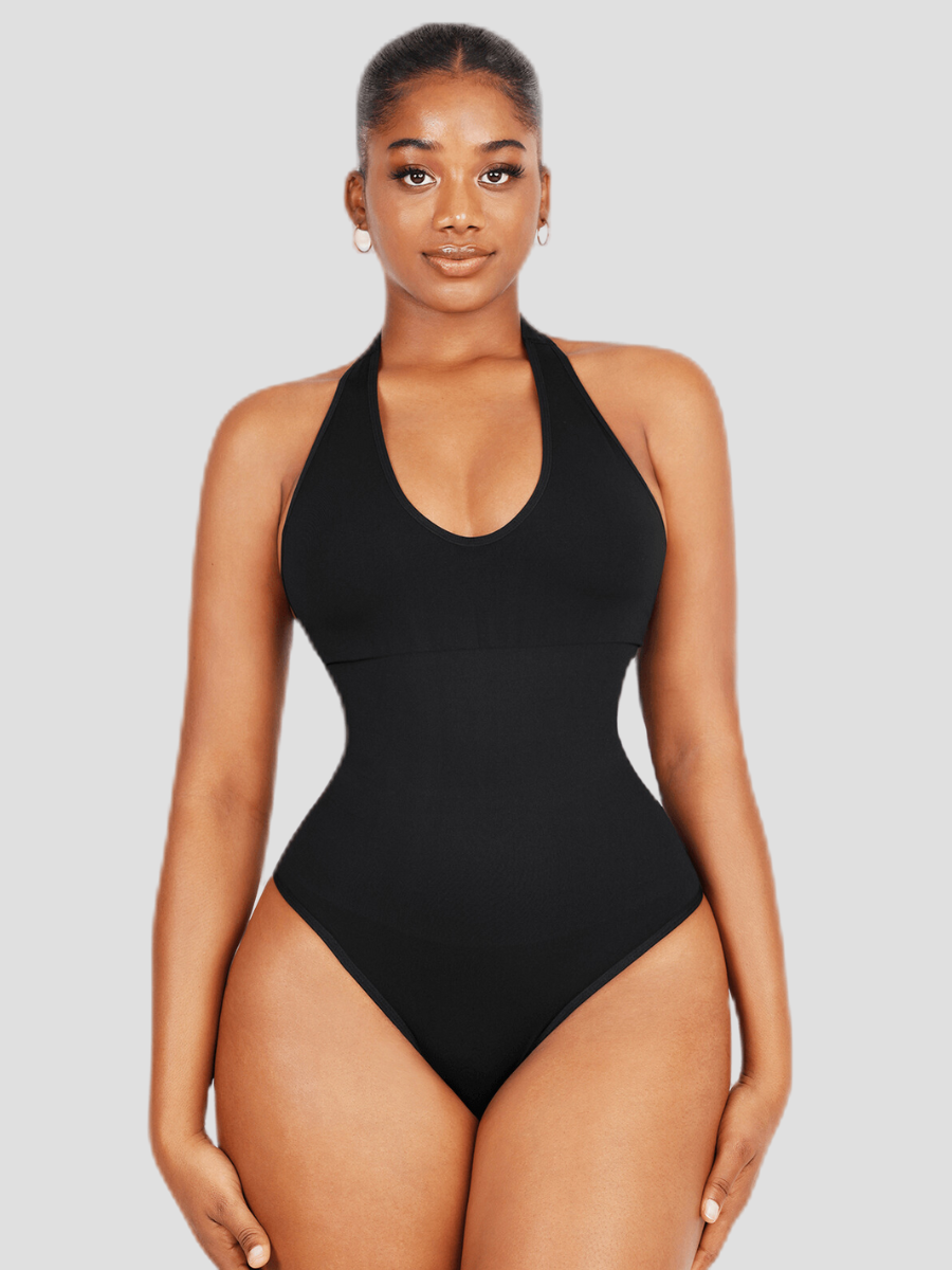 Woman wearing a black halter-style shapewear bodysuit with built-in removable bra padding and a seamless thong design.