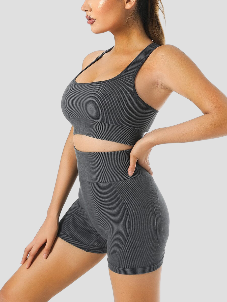 Woman wearing ribbed high-waisted black  activewear shorts and a matching sports bra designed by BodyFlexx.