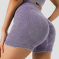 Woman wearing short purple ribbed activewear shorts with a scrunch bum designed by BodyFlexx.