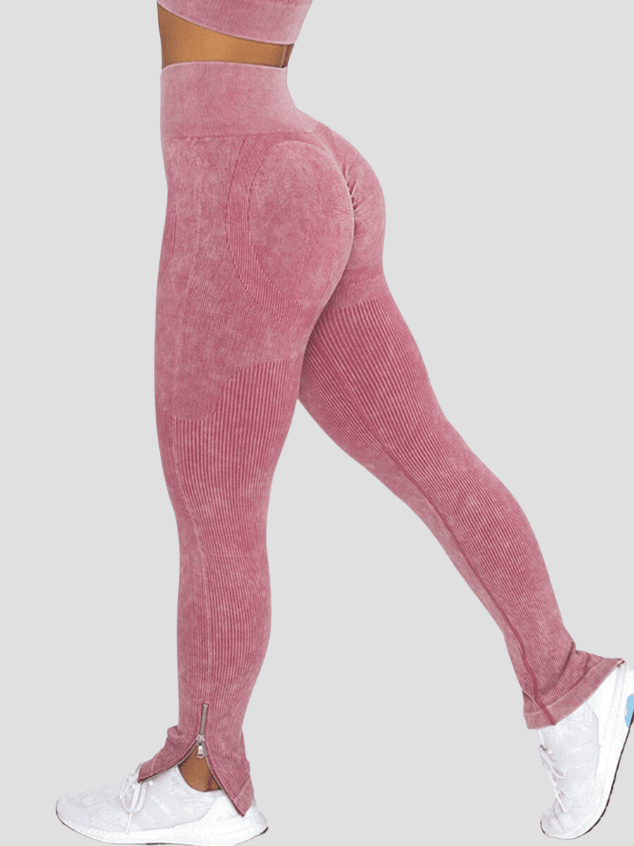 Woman wearing high-waisted ribbed pink leggings with a stylish bottom zipper on each leg.