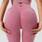 Woman wearing high-waisted ribbed pink leggings showing the scrunch bum back seam and the BodyFlexx logo.