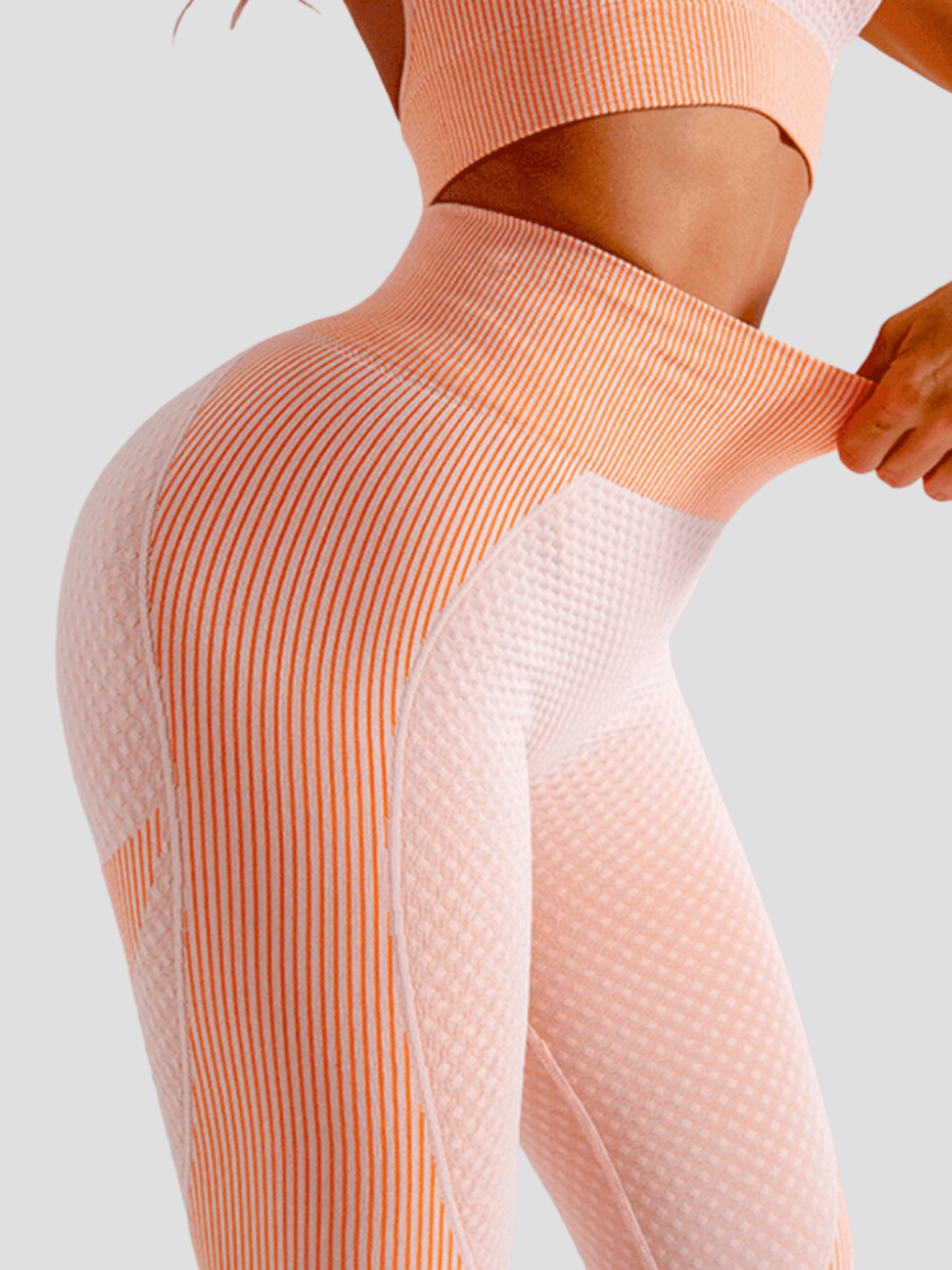 Woman wearing high waisted pink patterned color block leggings with tummy control by BodyFlexx.