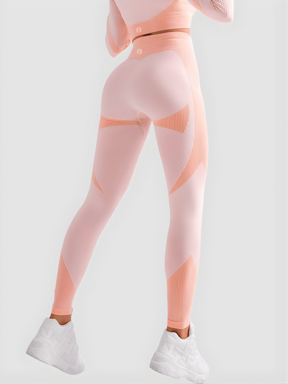 Woman wearing high waisted pink patterned color block tummy-control leggings by BodyFlexx.