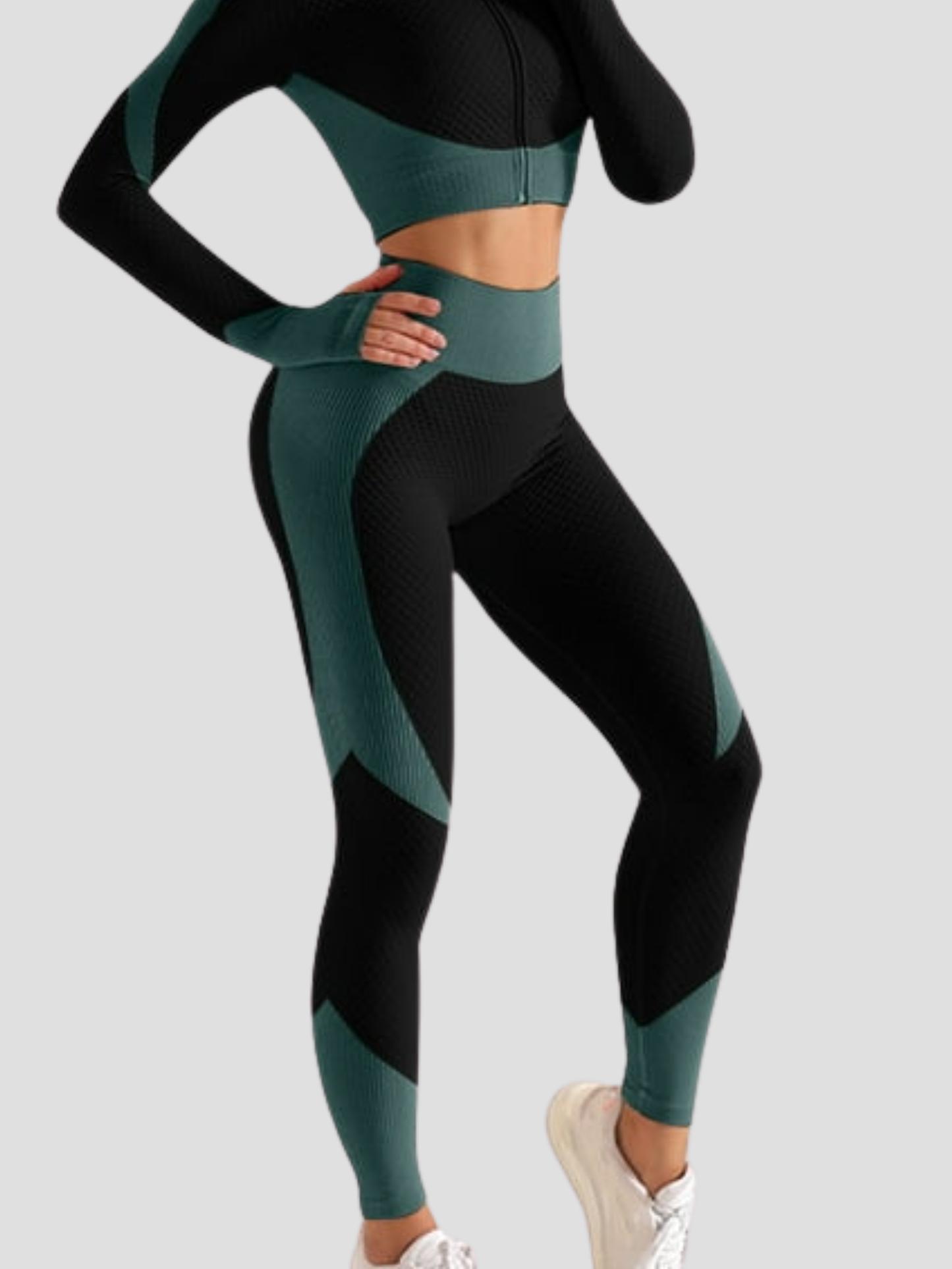 Woman wearing high waisted black and teal patterned color block leggings with a matching activewear jacket by BodyFlexx.