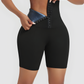Woman wearing black BodyFlexx Waist-Training Sauna shorts with a corset closure showing a sweaty stomach after a good workout.