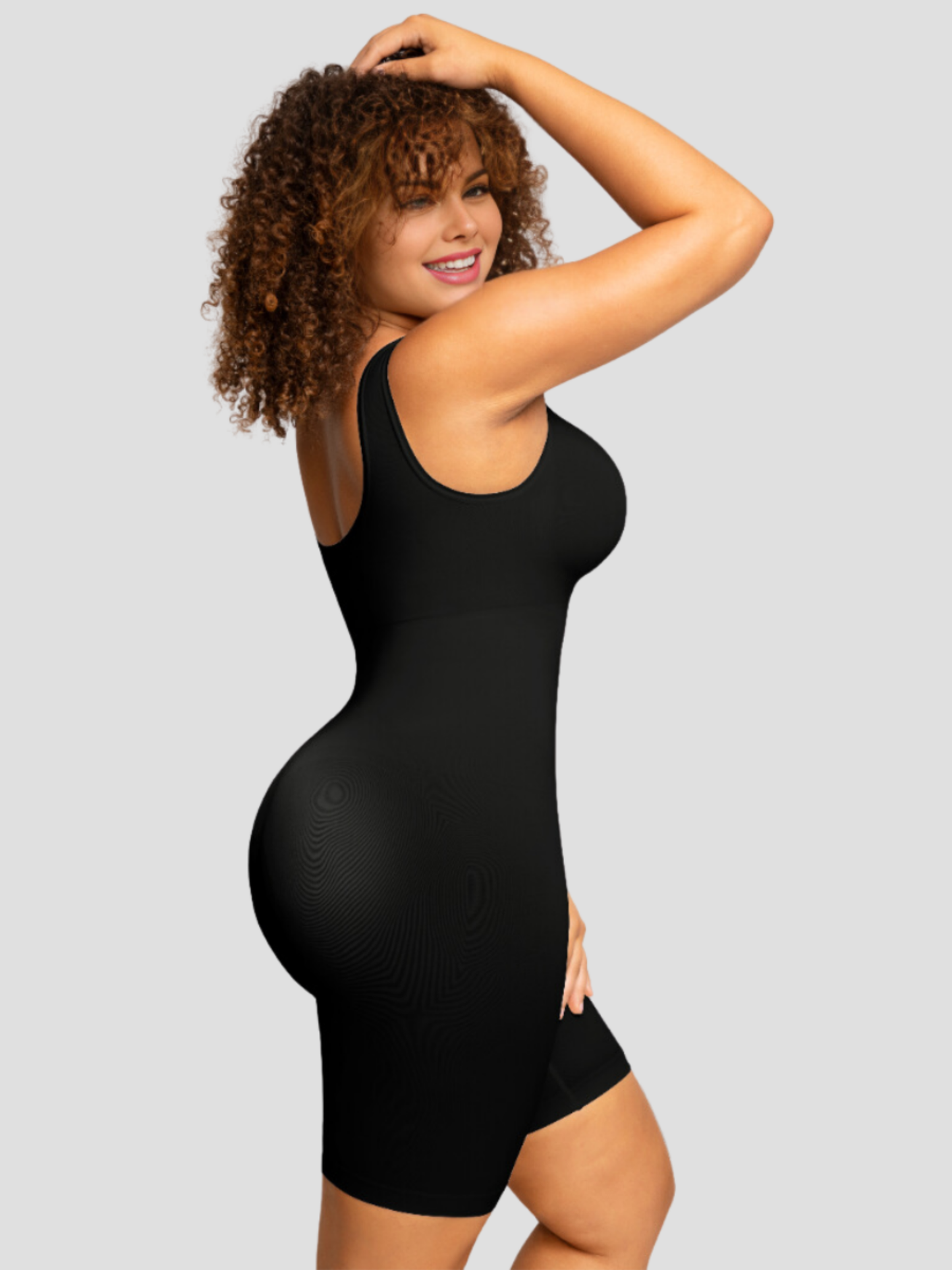Curvy woman wearing a black mid-thigh shapewear bodysuit designed by BodyFlexx.