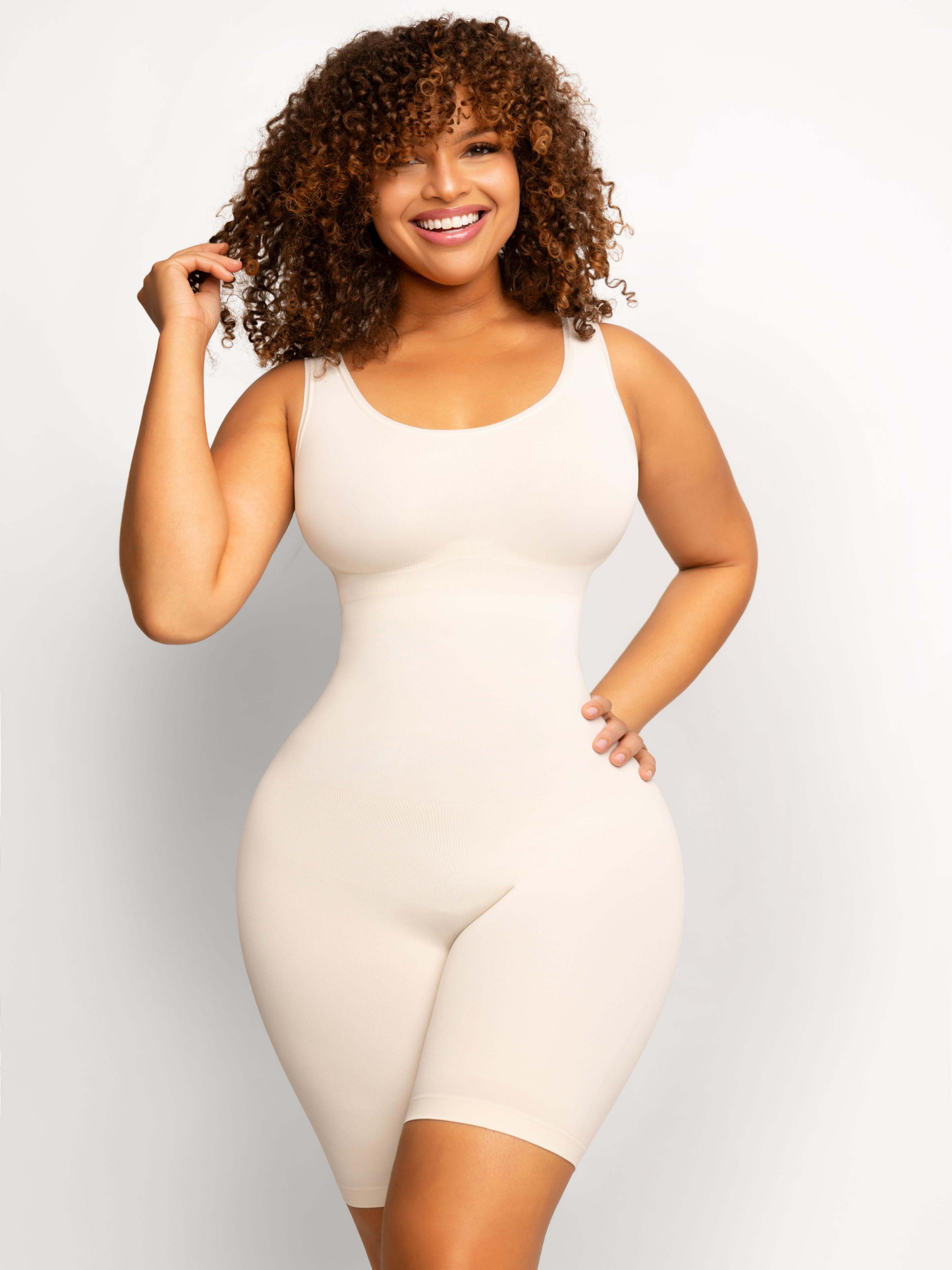 Woman wearing an ivory/white colored mid-thigh shapewear bodysuit by BodyFlexx.
