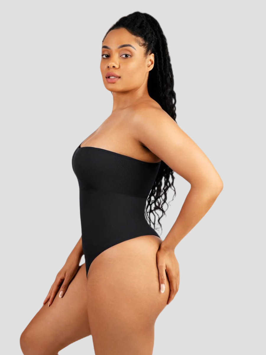 Woman posing wearing a black off-the-shoulder shaping bodysuit with built-in shapewear for tummy-control and hourglass curves.